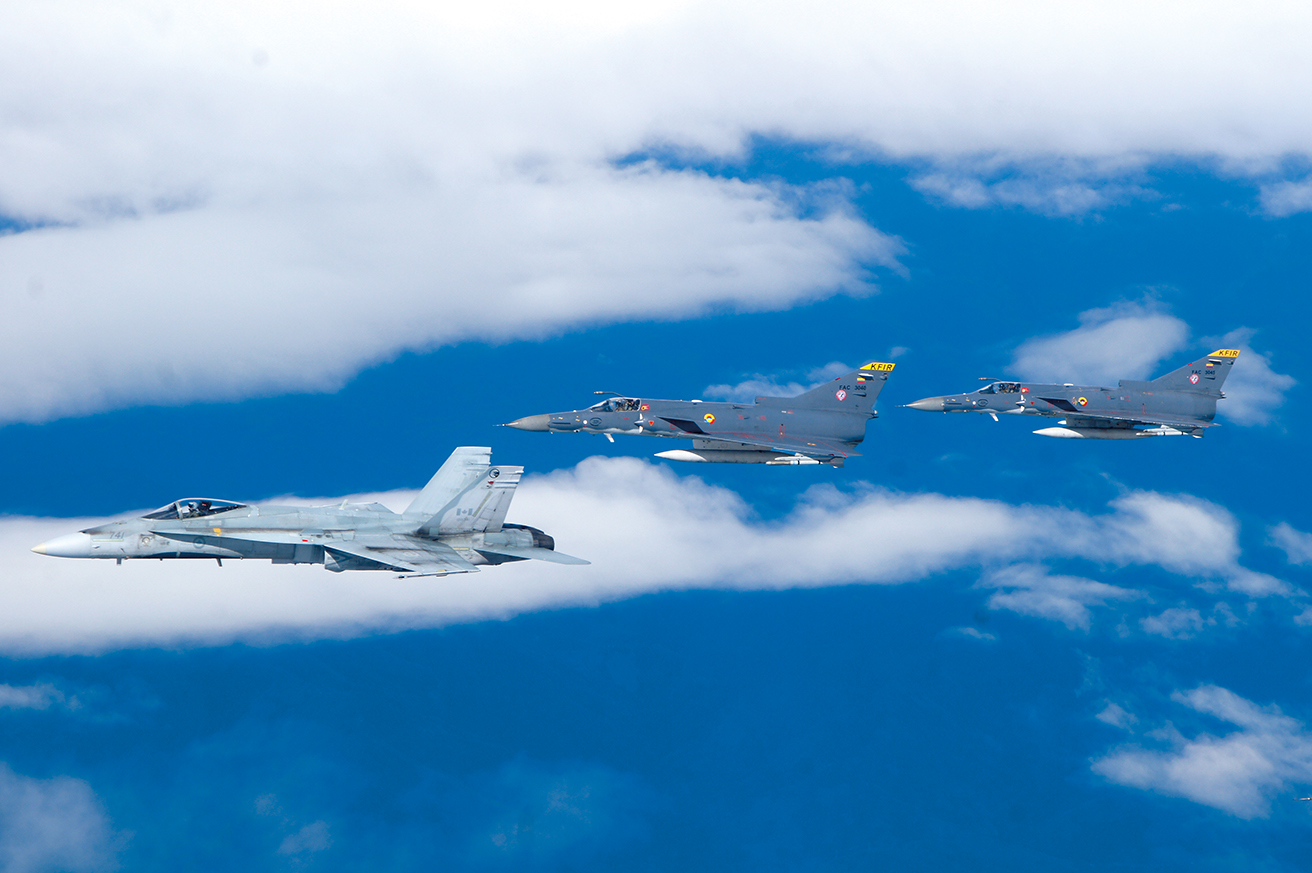 Formación de dos aeronaves Kfir de la FAC liderados por el CF-18 “Hornet” de la Real Fuerza Aérea Canadiense durante la F-AIR 2013. 