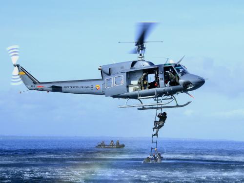 Comandos Especiales Aéreos de la Fuerza Aérea Colombiana en entrenamiento de recuperación de personal en aguas abiertas por medio de escalera textil, desplegada desde un helicóptero Bell 212.